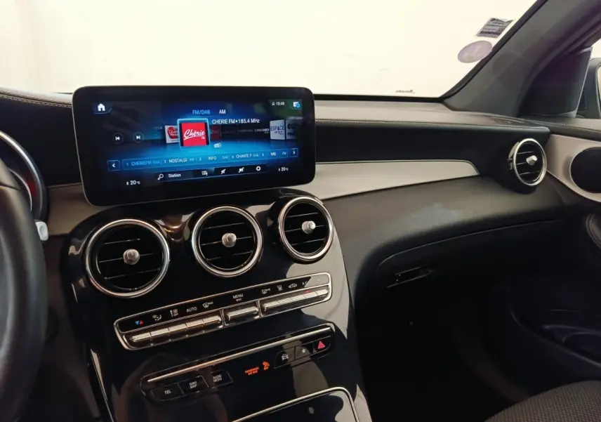 Vue intérieure du tableau de bord noir et beige du Mercedes GLC 300 DE Business Line avec écran tactile central.