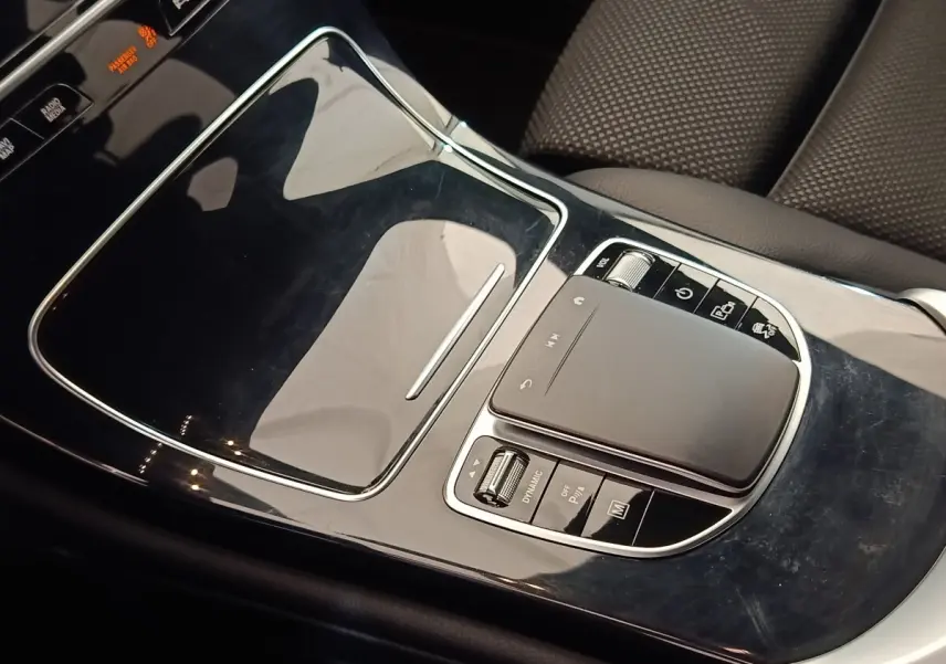 Gros plan sur la console centrale noire brillante du Mercedes GLC 300 DE Business Line 2022, avec pavé tactile et commandes.