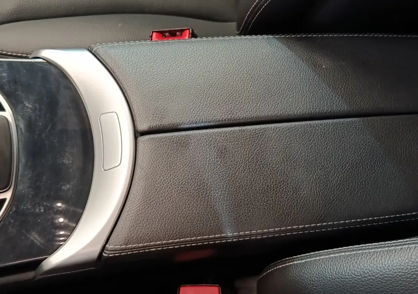 Détail de l'accoudoir central en cuir noir avec coutures blanches dans l'habitacle d'une Mercedes GLC 300 hybride rechargeable.