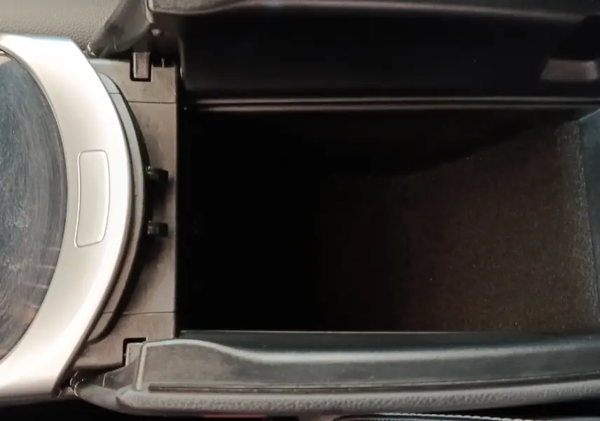 Vue rapprochée de la console centrale ouverte du Mercedes GLC bleu, montrant le compartiment de rangement intérieur.