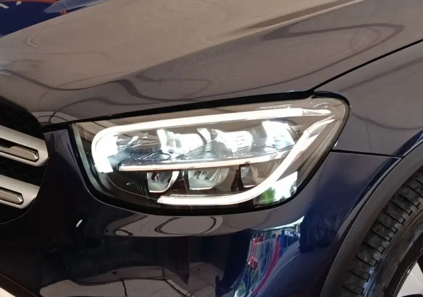 Gros plan sur le phare avant droit LED d’un Mercedes GLC 300 DE Business Line bleu 2022.