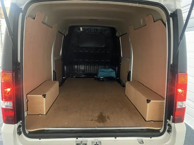 Vue arrière ouverte du fourgon blanc DFSK EC35 SERES ECOCITY 11900 HT, montrant l'espace de chargement en bois.