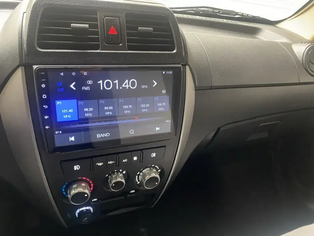 Vue rapprochée du tableau de bord noir du DFSK EC35 blanc, mettant en valeur l'écran tactile central et les commandes de climatisation.