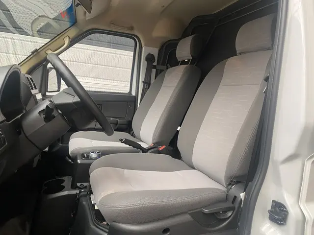 Intérieur côté conducteur du DFSK EC35 blanc 2023, montrant les sièges gris et le volant multifonctions.