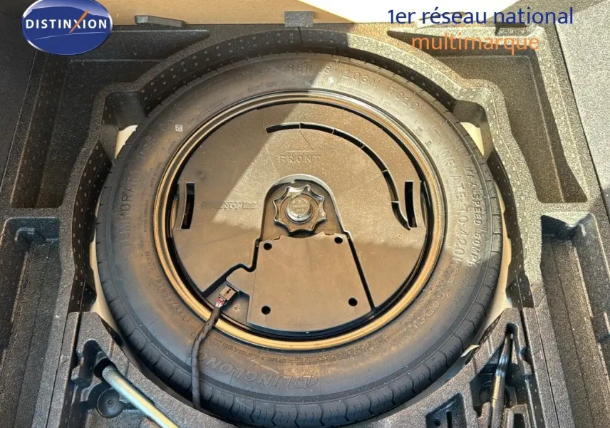 Gros plan sur la roue de secours dans le coffre d'un Skoda Kodiaq blanc 2018, avec rangement en mousse noire.