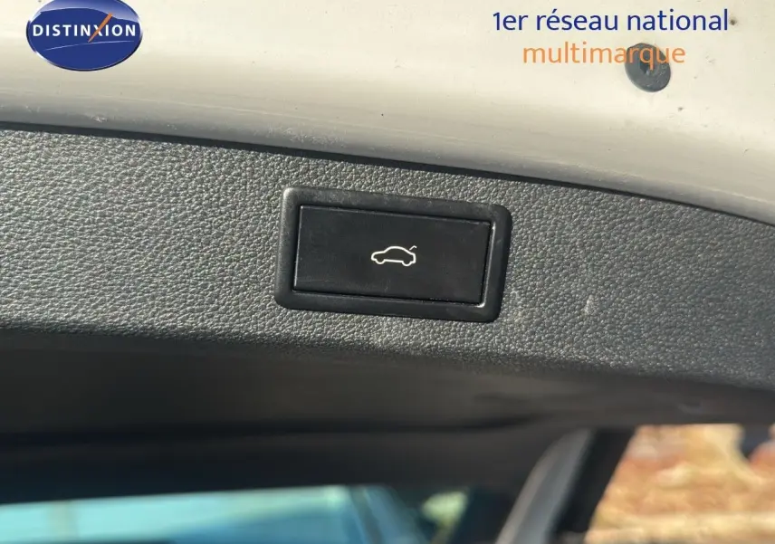 Bouton de déverrouillage électrique du hayon sur un Skoda Kodiaq blanc 2018, vue intérieure du coffre.