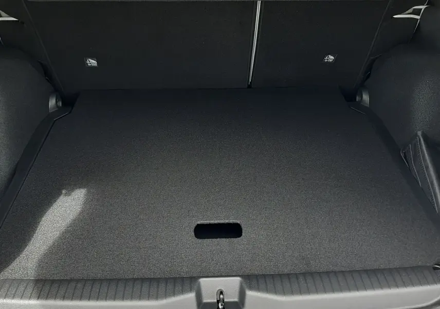 Coffre ouvert du Citroën C3 Aircross blanc banquise avec plancher plat et intérieur noir, vue de l'arrière.