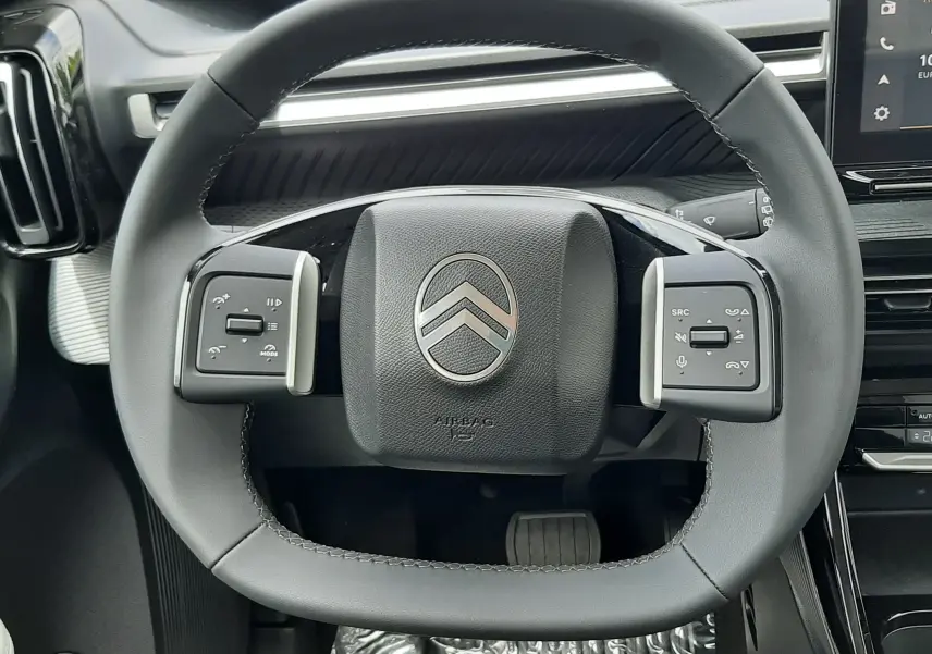 Vue rapprochée du volant noir de la Citroën C3 Aircross 2026, avec commandes intégrées et tableau de bord moderne.