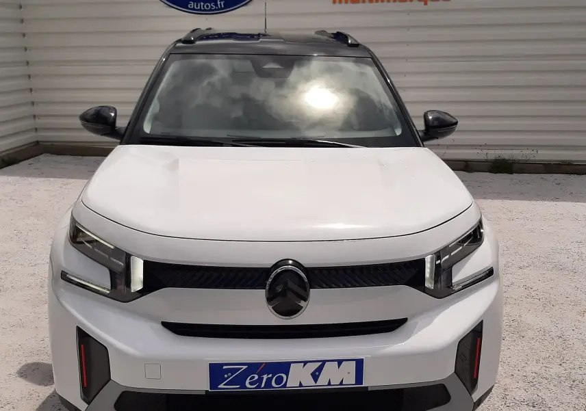 Vue avant d'un Citroën C3 Aircross blanc banquise avec toit noir, mettant en valeur ses phares LED et calandre distinctive.