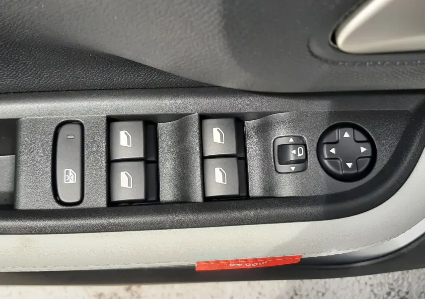 Gros plan sur les commandes des vitres et rétroviseurs côté conducteur du Citroën C3 Aircross blanc banquise avec intérieur noir et beige.