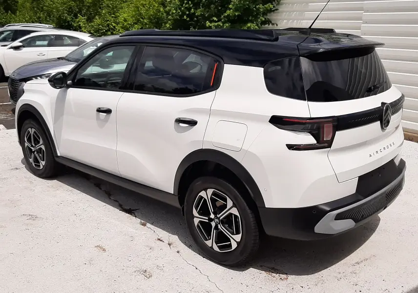 Vue 3/4 arrière droite du Citroën C3 Aircross blanc banquise avec toit noir et jantes distinctives en alliage.