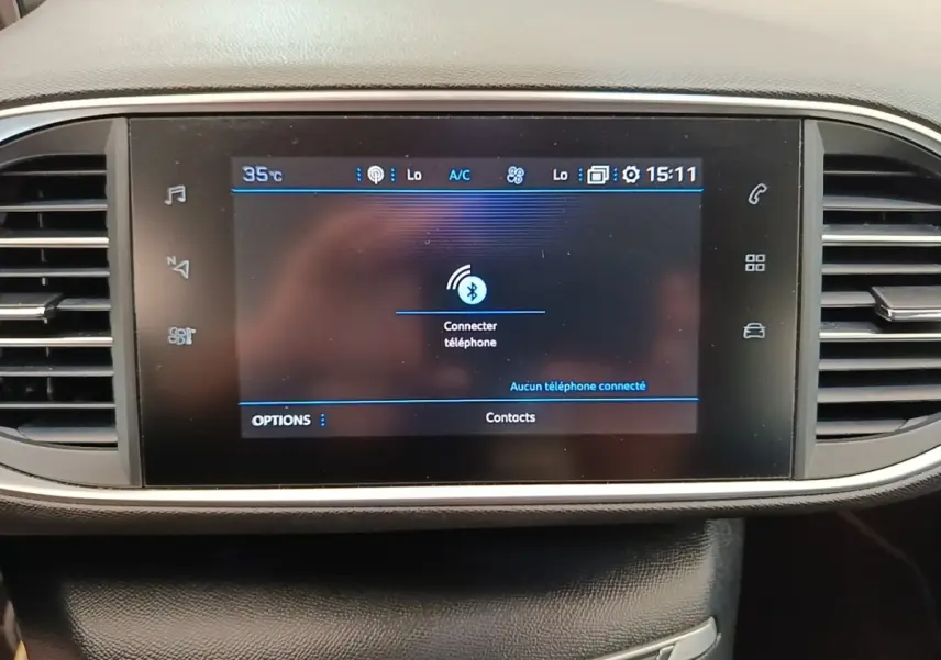 Écran tactile central du tableau de bord de la Peugeot 308 blanc, affichant la connexion Bluetooth au téléphone.