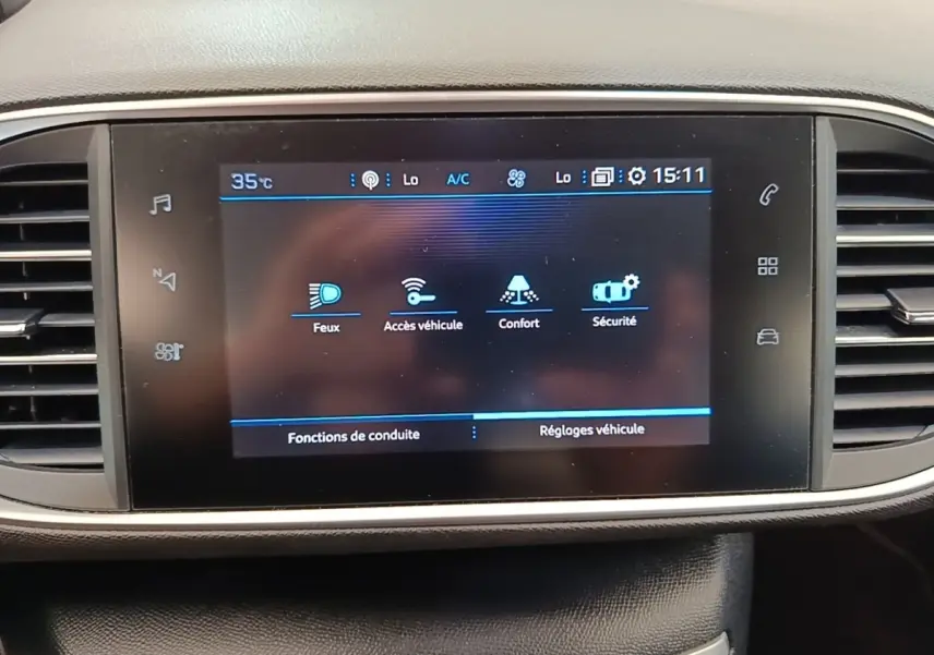 Écran tactile central de la Peugeot 308 blanc, affichant les réglages véhicule et fonctions de conduite.