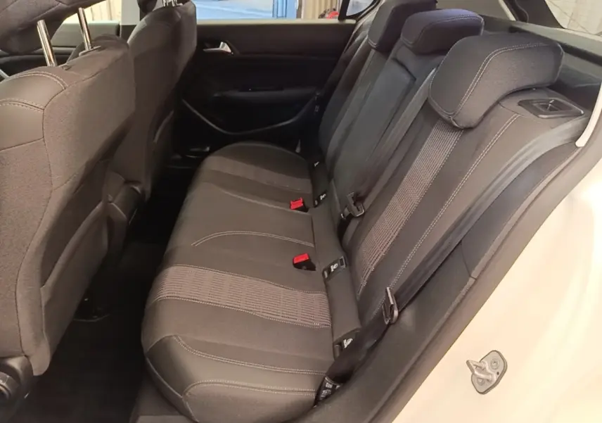 Vue intérieure côté droit de la banquette arrière noire de la Peugeot 308 blanche, avec ceintures et appuie-têtes visibles.