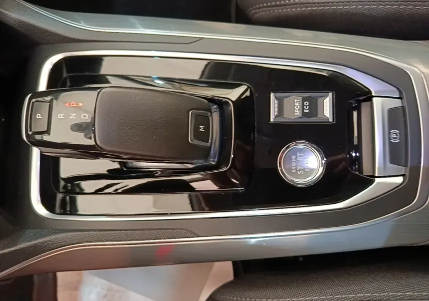 Vue rapprochée de la console centrale noire brillante avec levier de boîte auto et bouton start/stop de la Peugeot 308.