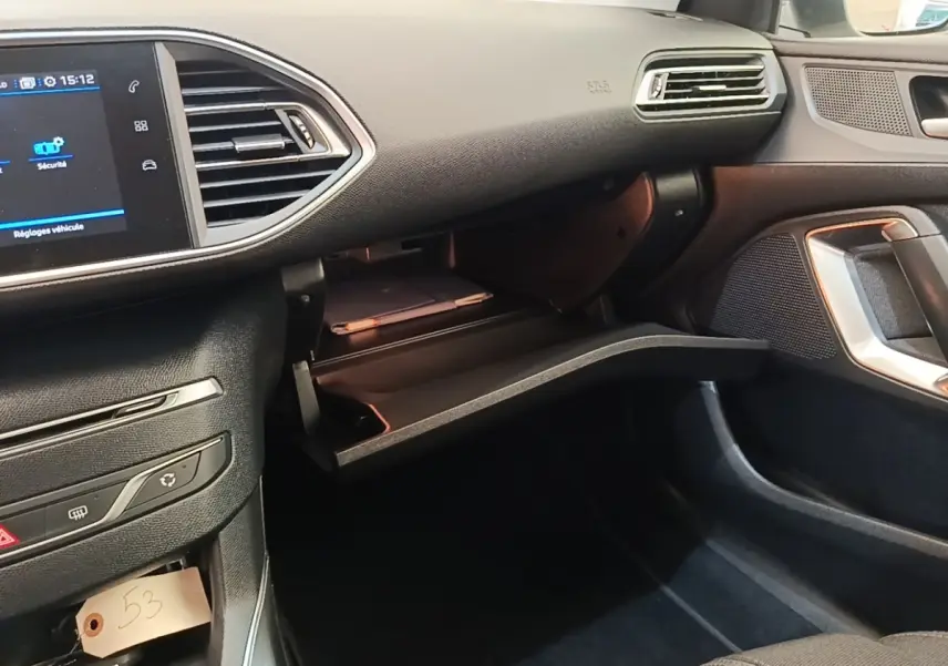 Vue intérieure côté passager de la Peugeot 308 2020 avec boîte à gants ouverte et écran tactile visible.