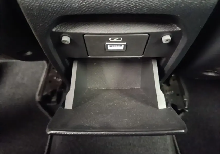 Gros plan sur le rangement réfrigéré ouvert avec prise 12V dans l'habitacle noir de la Peugeot 308 2020.