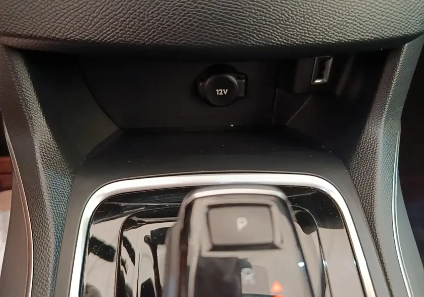 Gros plan sur la console centrale noire de la Peugeot 308 2020 avec levier de boîte automatique et prise 12V visible.