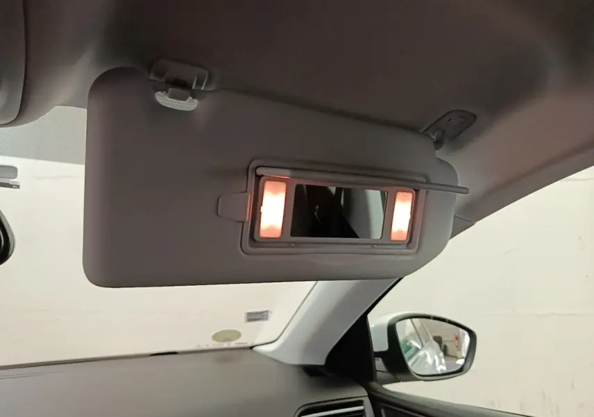 Pare-soleil côté conducteur de Peugeot 308 blanc 2020 avec miroir éclairé et rétroviseur extérieur visible.