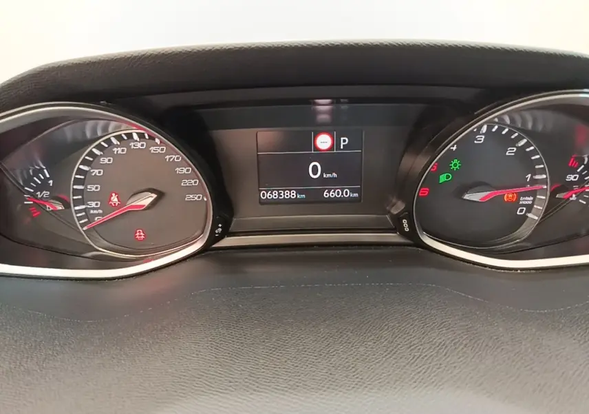 Vue rapprochée du tableau de bord numérique de la Peugeot 308 blanc, affichant 0 km/h et 68 388 km au compteur.
