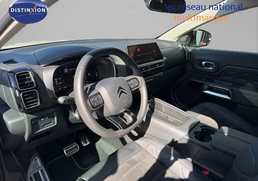 Intérieur de Citroën C5 Aircross 2023 vu côté conducteur, tableau de bord moderne avec écran tactile et volant multifonction.