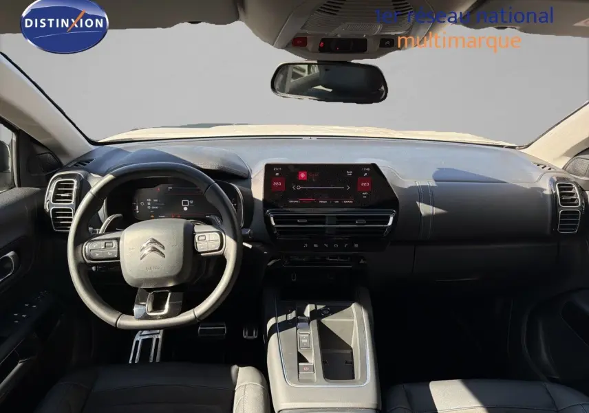 Vue intérieure avant du tableau de bord noir du Citroën C5 Aircross 2023 avec écran tactile et volant multifonction.