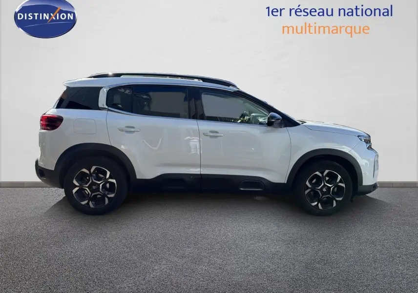 Profil droit d'un Citroën C5 Aircross blanc nacré 2023 avec toit noir et jantes alliage bicolores.