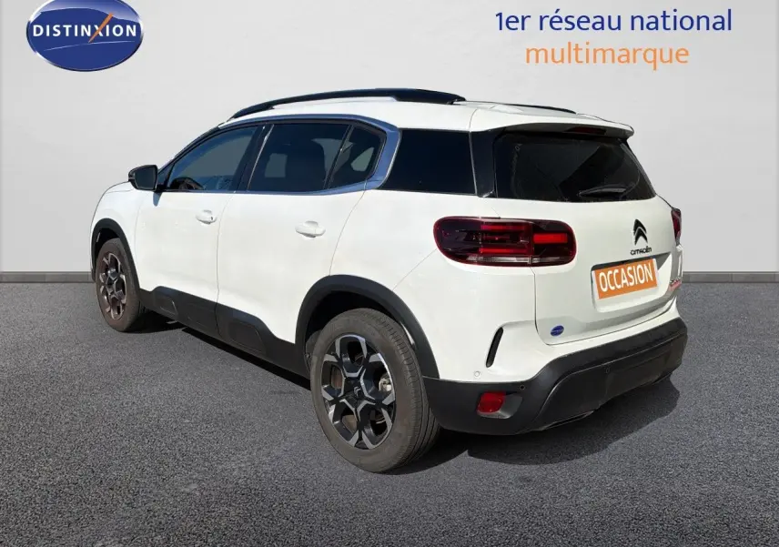 Vue 3/4 arrière droite d'un Citroën C5 Aircross blanc nacré avec toit noir et jantes alliage foncé.
