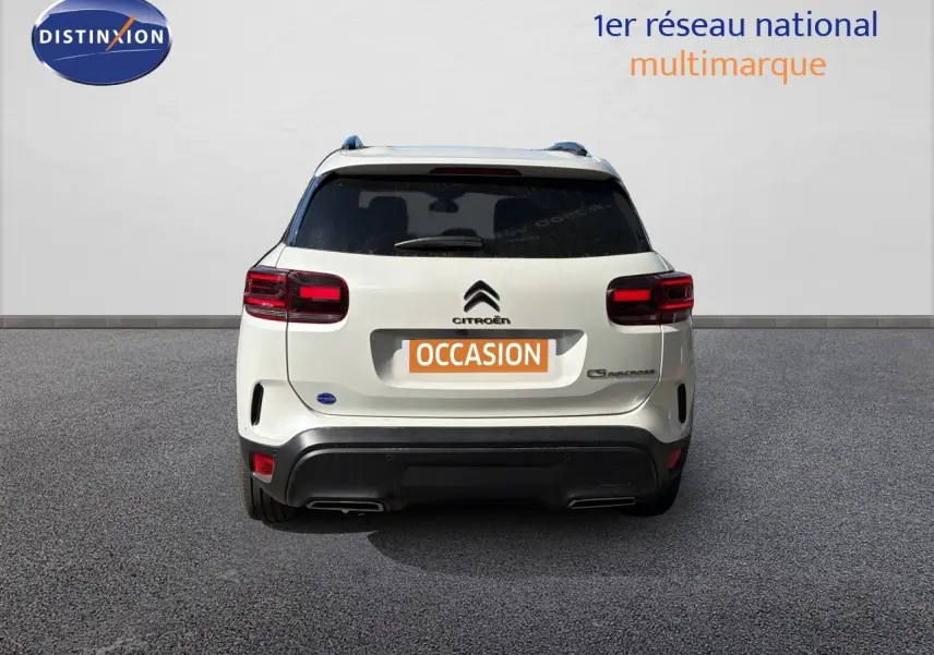 Vue arrière d'un Citroën C5 Aircross blanc nacré métal avec feux rouges et logo centré sur fond neutre.