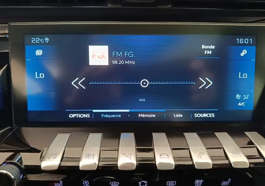 Écran tactile central de la Peugeot 508 gris foncé affichant la radio FM et commandes piano en façade.