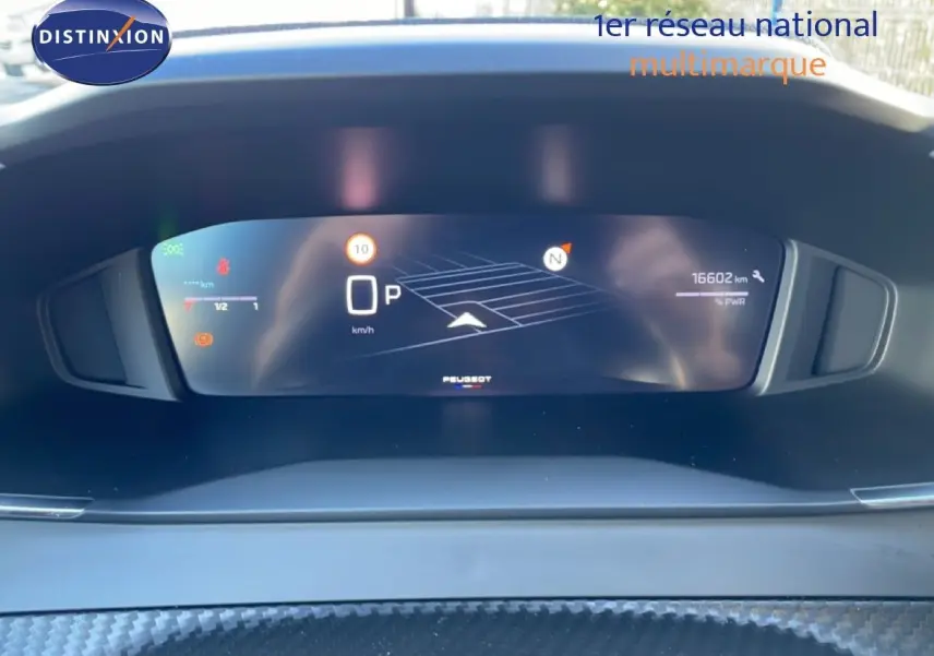 Vue rapprochée du tableau de bord numérique de la Peugeot 208 noire, affichant la vitesse et la navigation.