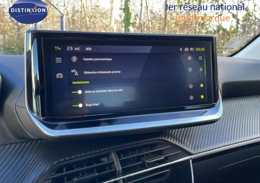 Écran tactile central affichant les aides à la conduite dans l’habitacle d’une Peugeot 208 noire, vue de face.