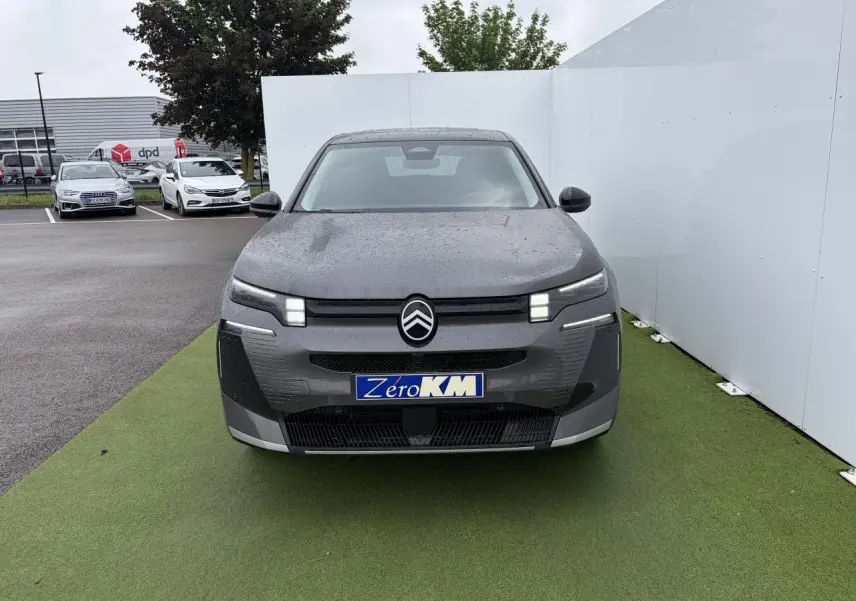 Vue frontale d'un Citroën C5 Aircross 2026 gris platinium avec toit noir et feux LED distinctifs allumés.