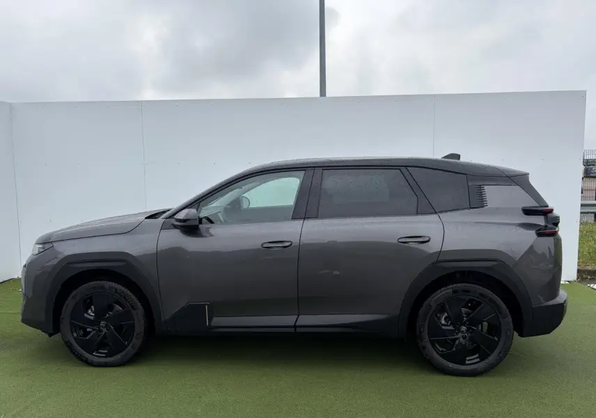 Vue de profil côté gauche d'un Citroën C5 Aircross 2026 gris platinium avec toit noir et jantes alliage noires.