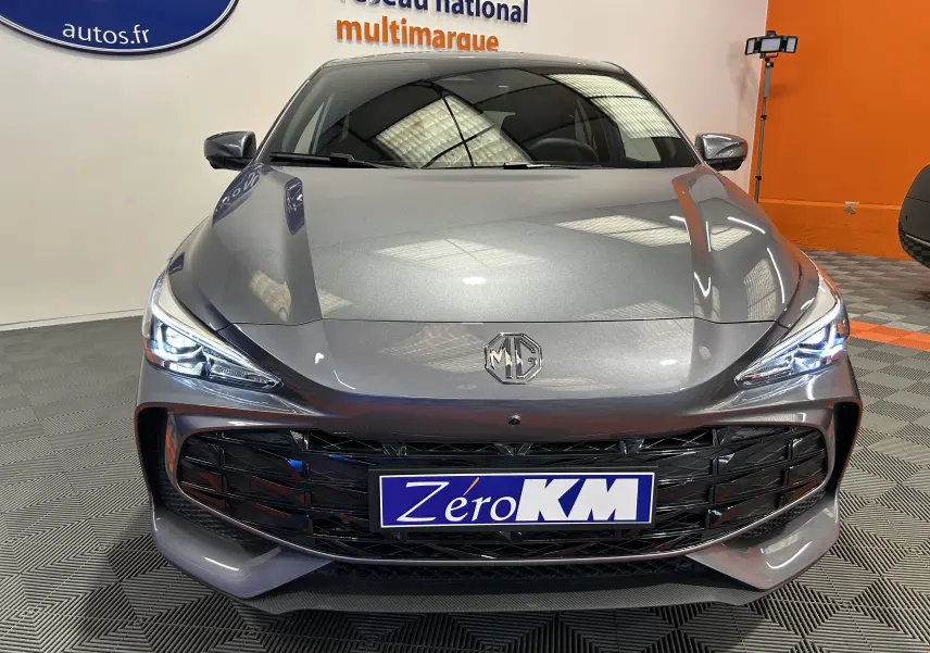 Vue frontale d'une MG3 1.5 Hybrid+ 195 Luxury gris Hampstead avec calandre noire et phares LED allumés.