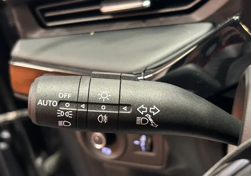 Gros plan sur la commande des phares et clignotants du MG3 1.5 Hybrid+ 195 Luxury en intérieur noir.