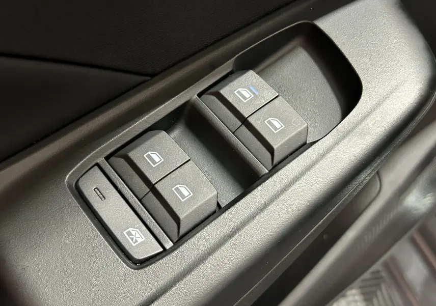 Gros plan sur les commandes des vitres électriques côté conducteur du MG3 1.5 Hybrid+ 195 LUXURY en intérieur noir.