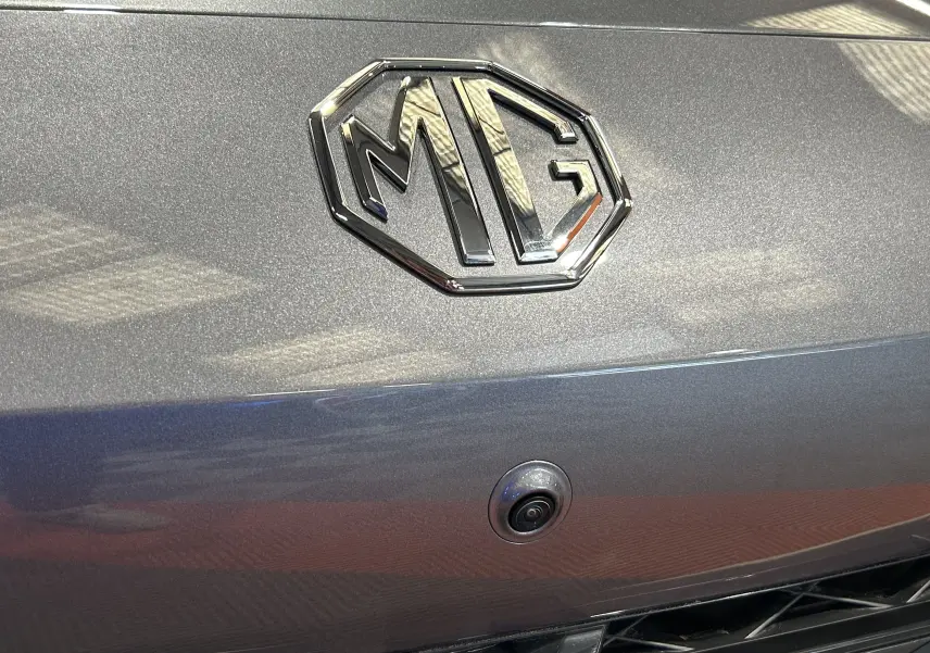 Gros plan sur le logo MG et la caméra 360° intégrée sur la calandre grise Hampstead du MG3 1.5 Hybrid+ 195 LUXURY 2026.