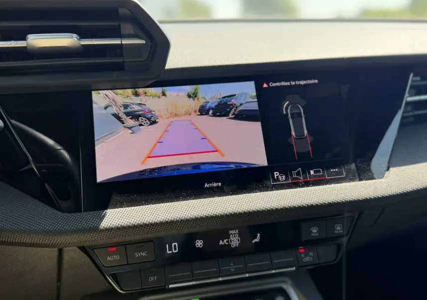 Vue rapprochée de l'écran central affichant la caméra de recul et l'aide au stationnement de l'Audi A3 Sportback Bleu Navarre.