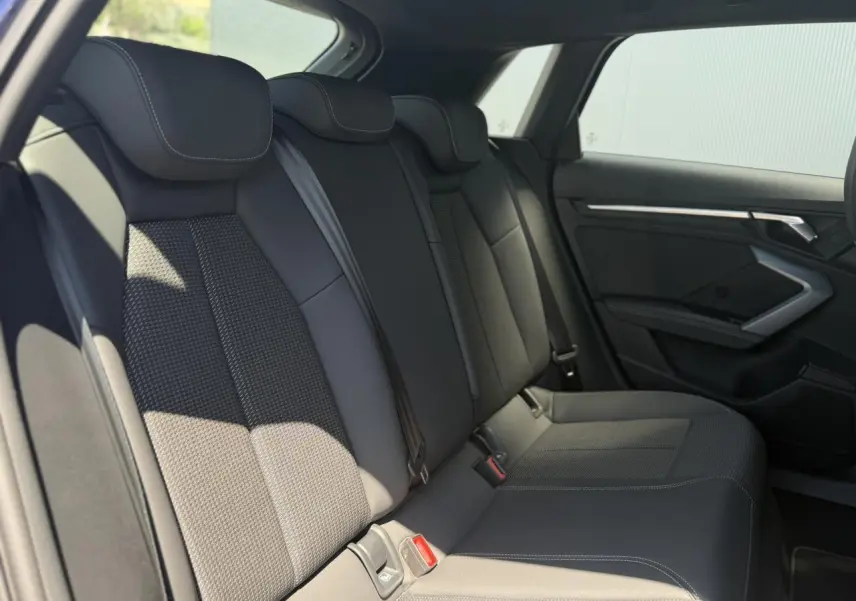 Vue intérieure côté droit des sièges arrière noirs en tissu et cuir de l'Audi A3 Sportback 2025.