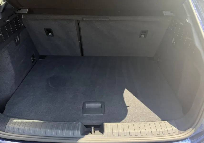 Coffre ouvert vu de face d'une Audi A3 Sportback Bleu Navarre avec intérieur de coffre noir et tapis plat.