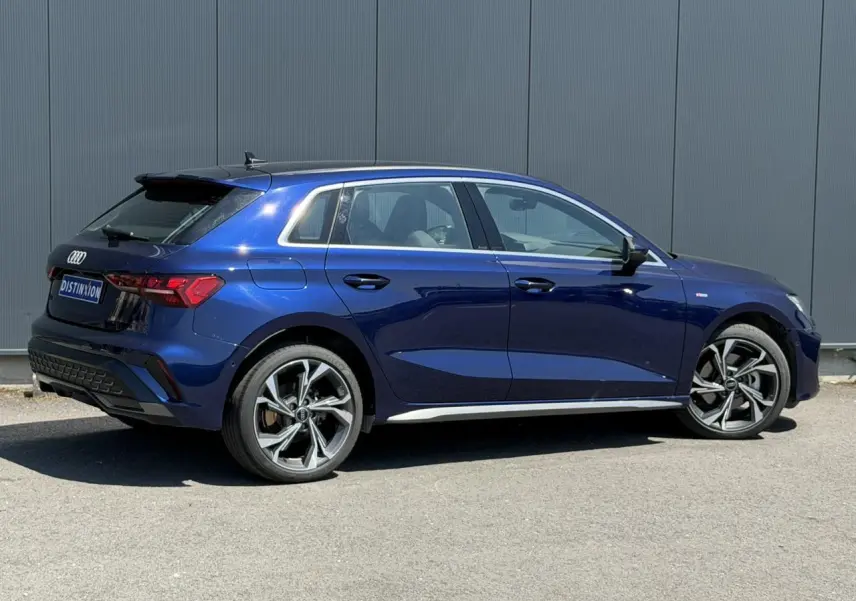 Audi A3 Sportback bleu Navarre vue de profil côté gauche, avec jantes alliage 5 branches en Y et toit noir.