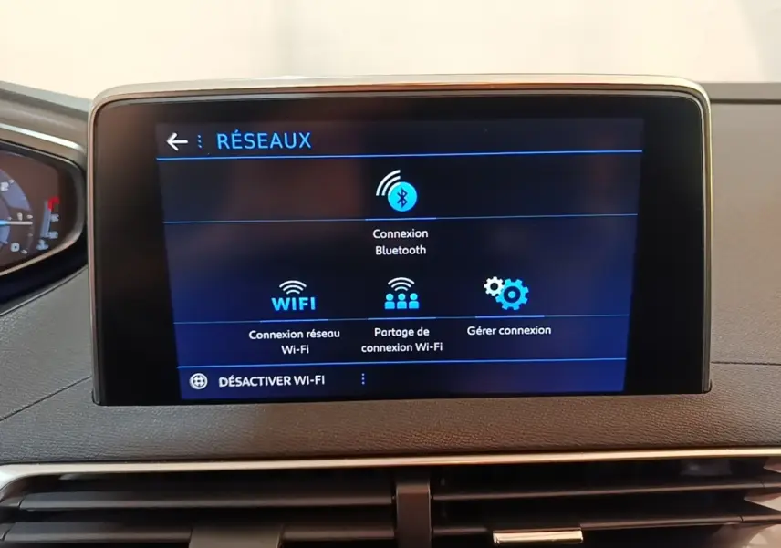 Écran tactile central du tableau de bord du Peugeot 5008 noir, affichant les options de connexion réseau Bluetooth et Wi-Fi.