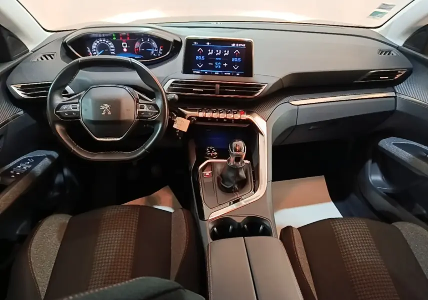 Vue intérieure avant du Peugeot 5008 2018 noir, tableau de bord avec écran tactile et volant multifonctions cuir.