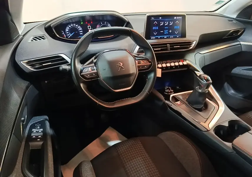 Vue intérieure avant du Peugeot 5008 noir, mettant en valeur le volant cuir multifonctions et l’écran tactile central.