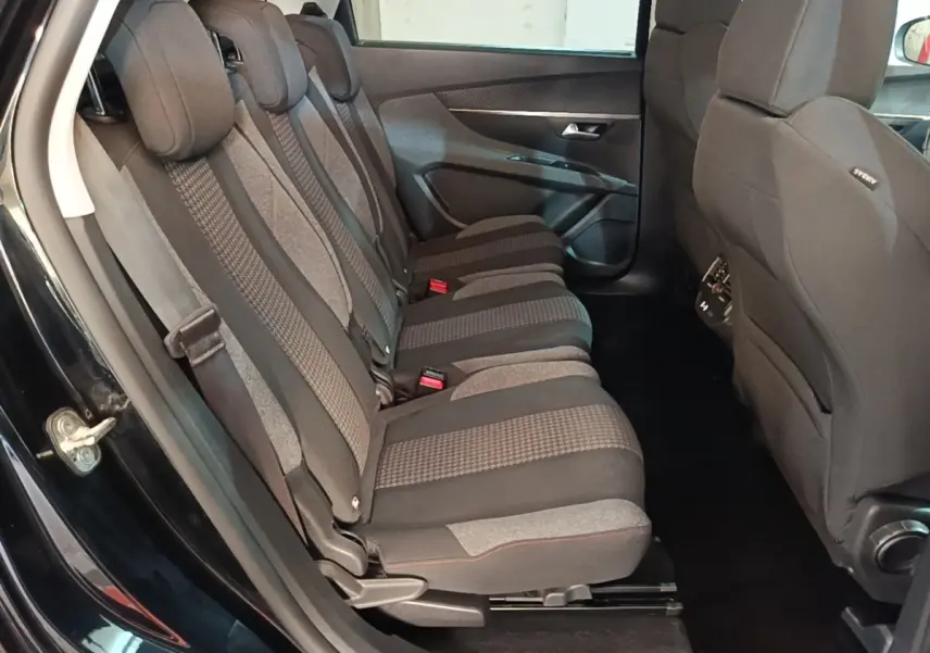 Vue latérale intérieure du siège arrière droit du Peugeot 5008 noir, montrant les trois places individuelles en tissu gris et noir.