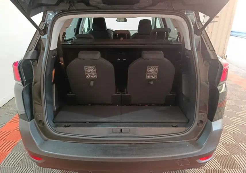 Vue arrière ouverte du Peugeot 5008 noir montrant les sièges arrière individuels et le coffre spacieux.