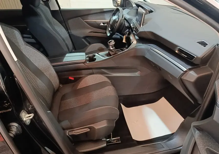 Intérieur avant droit du Peugeot 5008 noir 2018, sièges tissu gris et console centrale avec boîte manuelle.