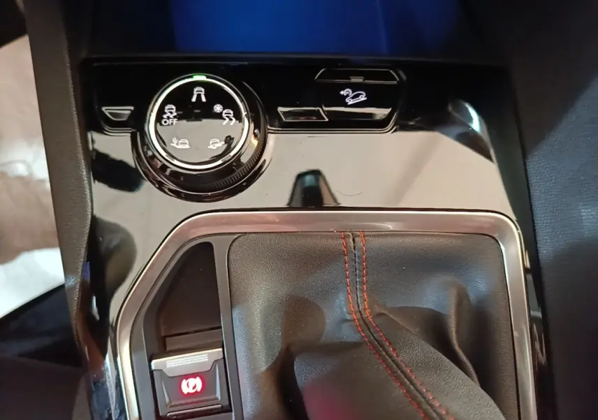 Gros plan sur la console centrale noire du Peugeot 5008 avec levier de vitesse manuel et commandes d’aide à la conduite.