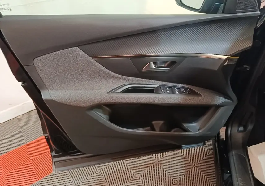 Vue rapprochée de la porte avant gauche noire du Peugeot 5008 2018, avec commandes des vitres et insert décoratif gris.